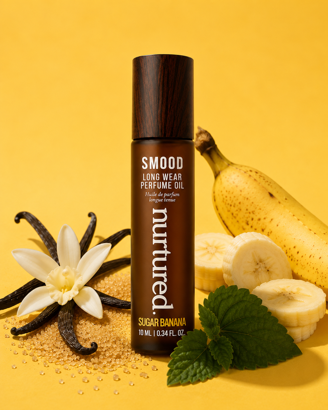 A bottle of SMOOD Long Wear Perfume Oil by nurtured, in the Sugar Banana scent, styled with banana slices, vanilla beans, mint leaves, and seeds on a bright yellow background.